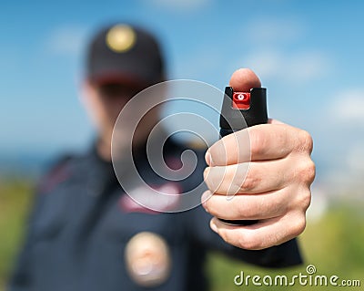 Detail of a police officer holding pepper spray. Stock Photo
