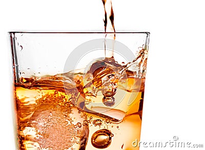 Detail of pouring scotch whiskey in glass with ice cubes on white Stock Photo