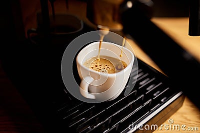 Detail of a professional coffe maker dripping coffe into an empty cup in a cafeteria Stock Photo