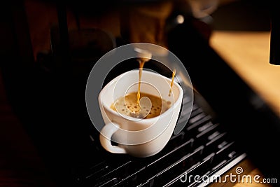 Detail of a professional coffe maker dripping coffe into an empty cup in a cafeteria Stock Photo