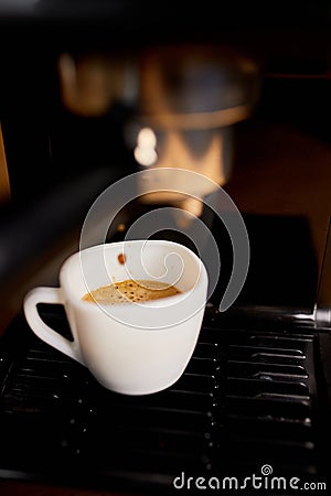 Detail of a professional coffe maker dripping coffe into an empty cup in a cafeteria Stock Photo