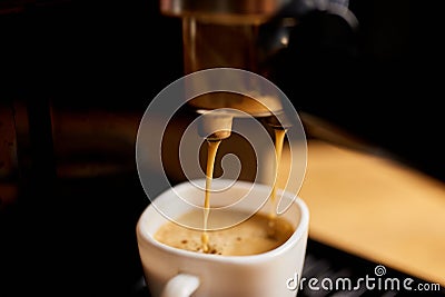 Detail of a professional coffe maker dripping coffe into an empty cup in a cafeteria Stock Photo