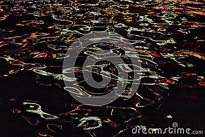 Detail of river at night with blue and red lights reflecting on highlights Stock Photo