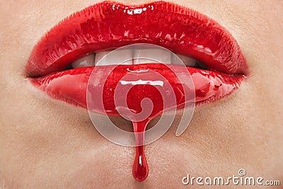 Detail shoT of red lipgloss dripping from woman`s lips Stock Photo