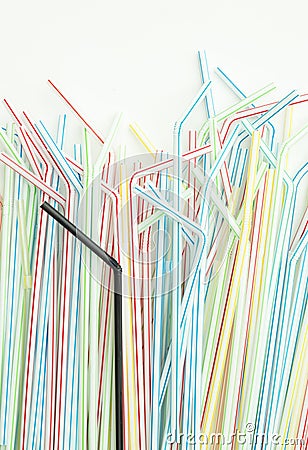 Detail of single black drinking straw into a group of colorful straws Stock Photo