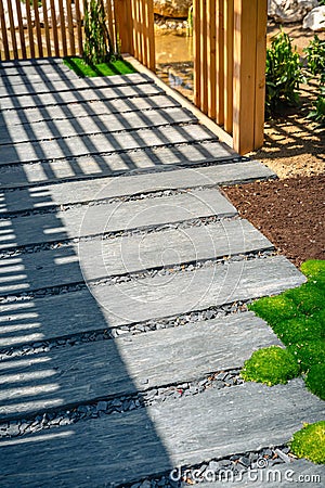 Detail of slate path with bark mulch and native plants in Japanese garden. Landscaping and gardening concept Stock Photo