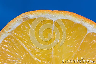 Detail on a Slice Orange on a Blue Background Stock Photo