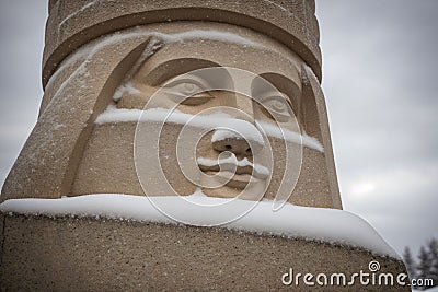 Detail of a snow-covered stone statue Stock Photo