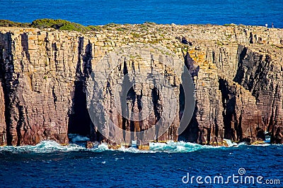 Detail of stratified cliff with breaking waves Stock Photo