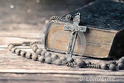 Detail studio shot of very old, vintage Holy Bible with lots of ornaments on the cover and yellow pages and old rosary Stock Photo