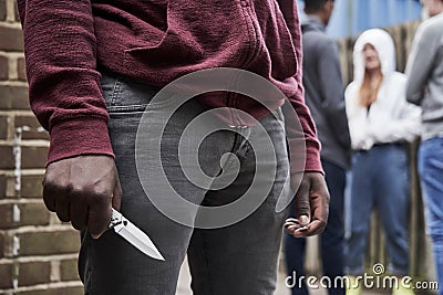 Close Up Of Teenage Boy In Urban Gang Holding Knife Stock Photo