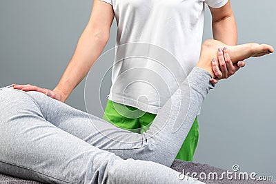 Detail of therapist manipulating female leg. Stock Photo