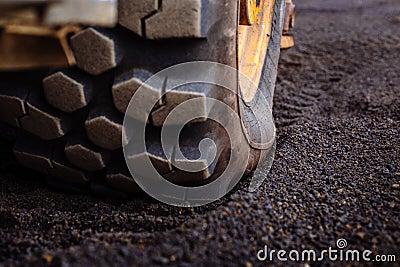 Detail on tire track pattern on a yellow heavy duty digger excavator Stock Photo