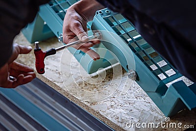 Detail of a turquoise metal staircase that is assembled by a worker with a screwdriver Stock Photo
