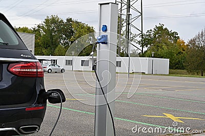 Detail view on charging of black electric car. Editorial Stock Photo
