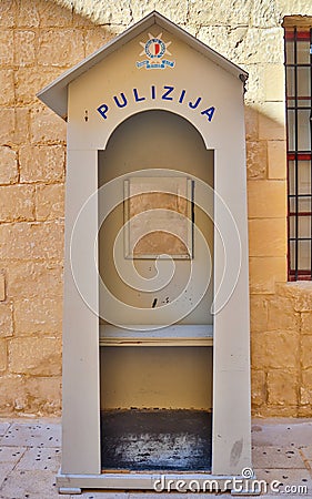 Detail view on a traditional and old maltese wooden police lodge. In the Background a sandstone wall Stock Photo