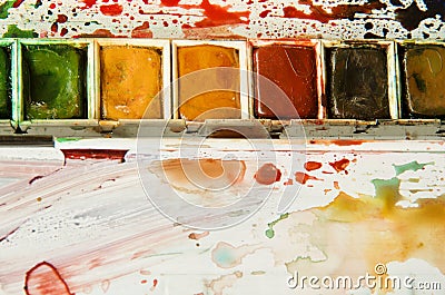 Detail of watercolor palette showing half pans of red, ochre, and green Stock Photo