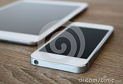 Detail of white mobile phone and white tablet Stock Photo