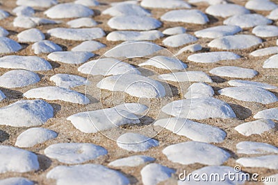 Detail of a white rounded pebble floor with white polished stone into a concrete subfloor Stock Photo