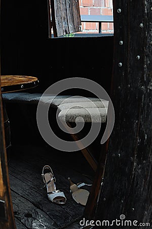 Detail of wooden cottage, entrance of empty hut with a pair of women`s shoes on floor Stock Photo