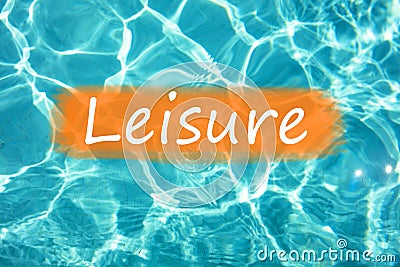 Detail of word `Leisure` on swimming pool water and sun reflecting on the surface Stock Photo