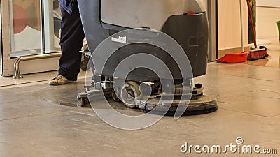 Worker cleaning store floor with machine. Stock Photo