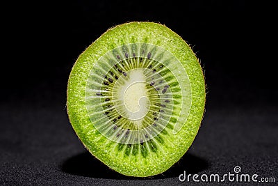 Detailed cross section of a fresh illuminated kiwi fruit cut in half Stock Photo