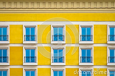 Detailed front view of a facade with windows with balconies and yellow wall Stock Photo