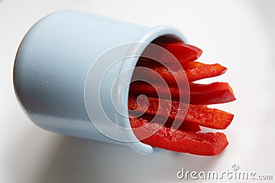 Detailed isolated copy space close up food shot of a pile of slices of fresh wet sweet red bell pepper in a blue round clay Stock Photo