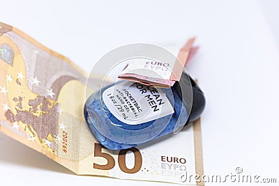 Detailed photo of a small pocket antibacterial hand gel surrounded by high value Euros Editorial Stock Photo