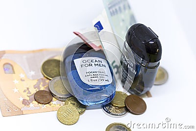 Detailed photo of two small pocket antibacterial hand gels surrounded by a pile of Euros reflecting its rising price and shortage Editorial Stock Photo