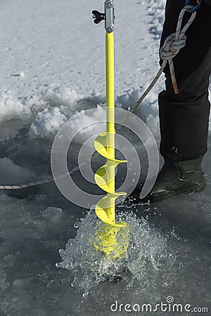 Detailed vertical image of ice auger drill drilling a hole in a frozen dam Stock Photo