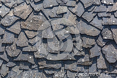 Detailed view of wall texture randomly lined with slate panels, typical and traditional shale stone material, used as external Stock Photo