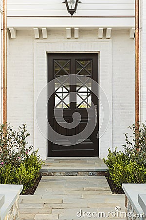 Detailed wooden front door of white brick home Stock Photo