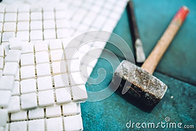 Details of construction tools, bathroom and kitchen renovation - pieces of mosaic ceramic tiles and rubber hammer Stock Photo