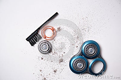 Details of a disassembled dirty shaver head and a cleaning brush on a light background. Soft selective focus. Copy space Stock Photo