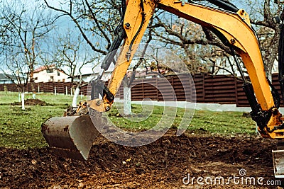 Details of excavator doing earth moving and digging during landscaping works Stock Photo