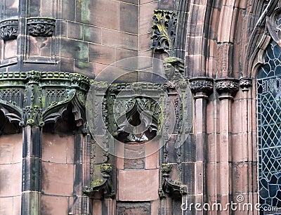 Details of ornately carved medieval stonework with niches and faces on the facade of chester cathedral Stock Photo