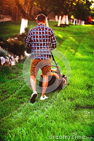 Details and portrait of gardener using industrial lawnmower. Gardening maintenance Stock Photo