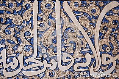 Details of stucco decoration with an Arabic writings painted in blue on the Palaces walls in Alhambra complex, Granada, Andalusia Stock Photo