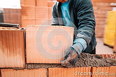 Details of worker hands laying bricks, putty knife, spatula and brick mortar Stock Photo
