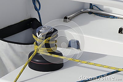 Details of yellow genoa sheet secured on self-tailing winch on sailing boat racer, boating concept Stock Photo