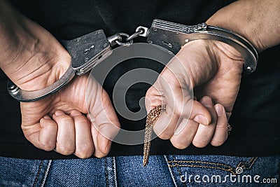 Detained man caught on theft of gold in a store. Handcuffed hands Stock Photo