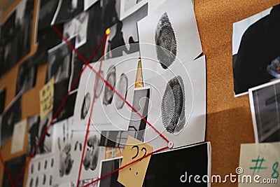 Detective board with crime scene photos, stickers, clues and red thread, closeup Stock Photo