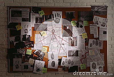 Detective board with fingerprints, photos, map and clues connected by red string on white brick wall Stock Photo