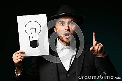 Detective holding paper sheet with light bulb as symbol of idea on dark background Stock Photo