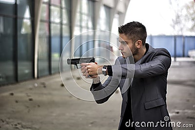 Detective or mobster or policeman aiming a firearm Stock Photo