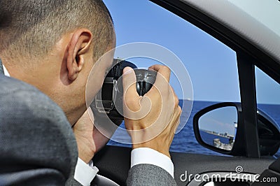 Detective or a paparazzi taking photos from inside a car Stock Photo