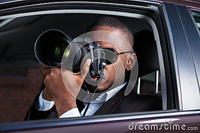 Detective Sitting Inside Car Photographing Stock Photo