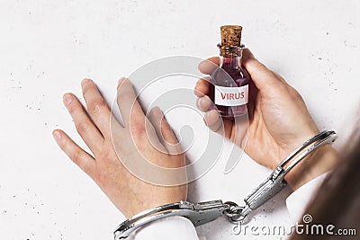 Detention for the illicit sale of toxic drugs. Doctor in handcuffs holding a bottle of virus Stock Photo